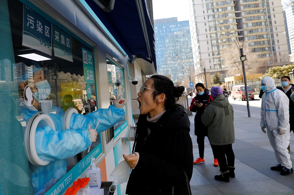 A medical worker collects a swab sample from a person at a mobile nucleic acid testing site for Covid-19 in Beijing, China February 23, 2022. u00e2u20acu2022 Reuters pic