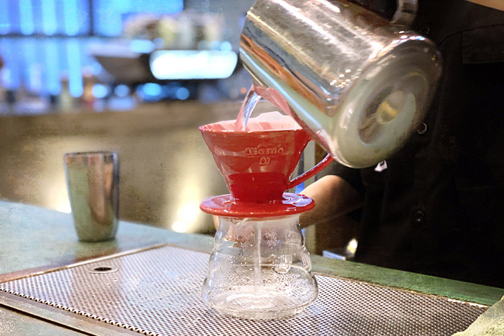 Rinsing the filter by pouring hot water through it.