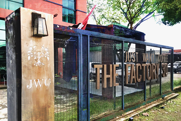 The bronzed gate separating the factory café and the industrial neighbourhood outside.