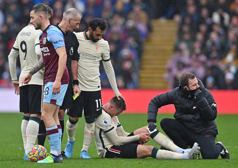 Liverpool midfielder Jordan Henderson holds his leg in pain after fouling Burnley defender Erik Pieters (unseen) during the English Premier League match at Turf Moor in Burnley, north west England, February 13, 2022. u00e2u20acu201d AFP pic 