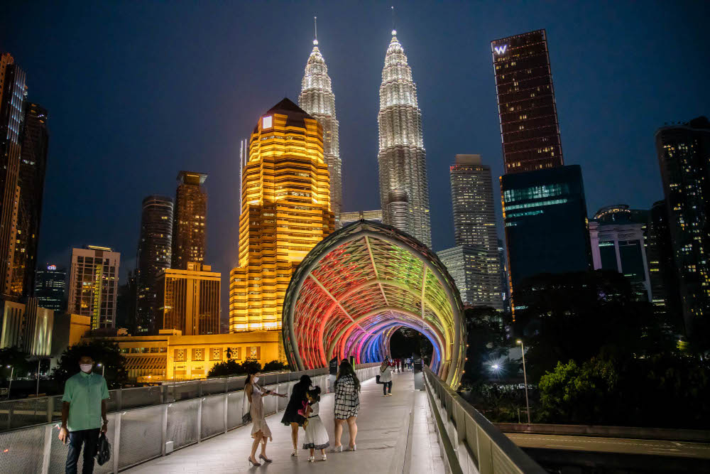 Pedestrians wearing face masks walk along the Saloma Link bridge in Kuala Lumpur, February 24, 2022. u00e2u20acu201d Picture by Firdaus Latif