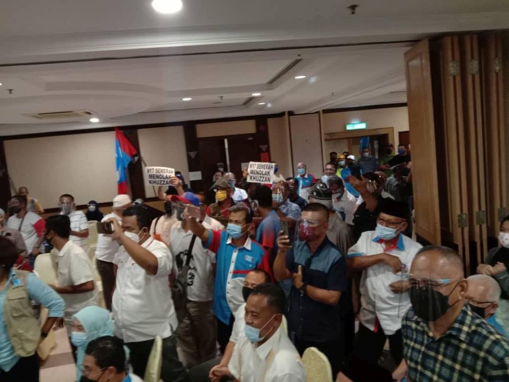 People claiming to be PKR members protest the partyu00e2u20acu2122s Semerah incumbent Mohd Khuzzan Abu Bakaru00e2u20acu2122s candidacy at the Pelican Hotel in Batu Pahat last night. u00e2u20acu201d Picture via Facebook