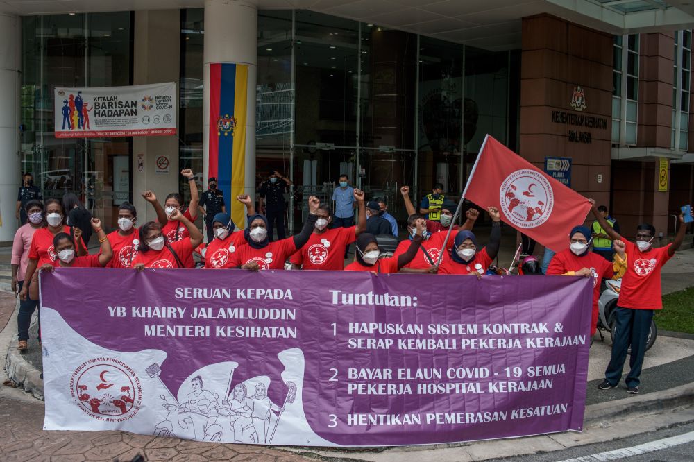 Representatives from the National Union of Workers in Hospital Support and Allied Services hold aloft a banner detailing their demands at the Ministry of Health in Putrajaya February 8, 2022. u00e2u20acu2022 Picture by Shafwan Zaidon