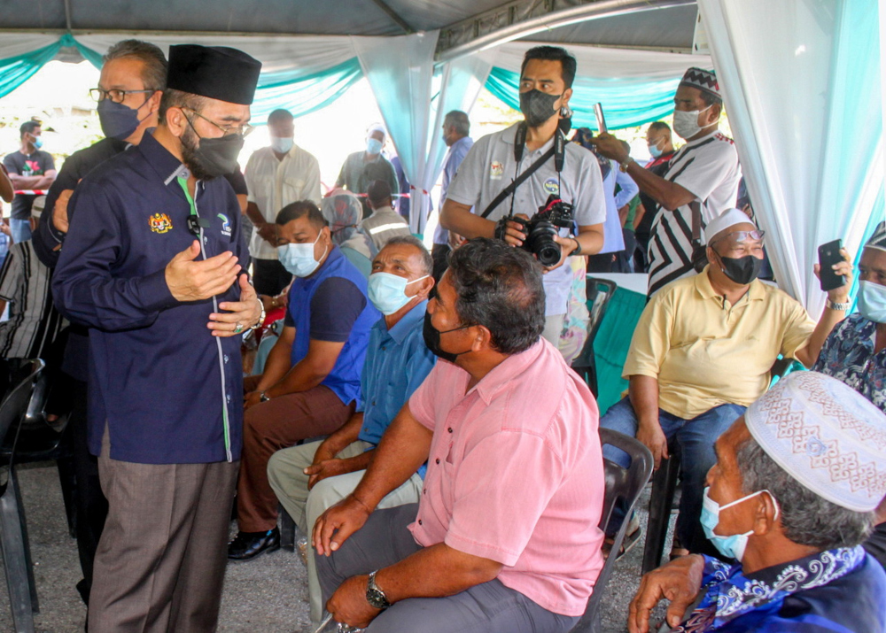 Deputy Agriculture and Food Industry Minister II Datuk Nik Muhammad Zawawi Salleh speaks to a recipient of the MAFI Prihatin assistance at the grounds of the Pasir Puteh parliamentary office in Kelantan, February 21, 2022. u00e2u20acu201d Bernama pic 
