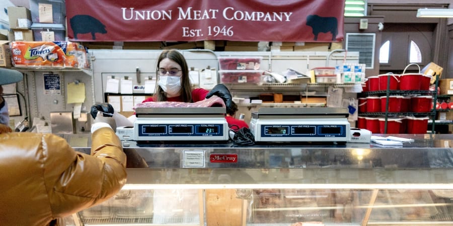 A customer pays for a cut of meat at Union Meat Company in Eastern Market in Washington, DC. u00e2u20acu201d ETX Studio picnnnn