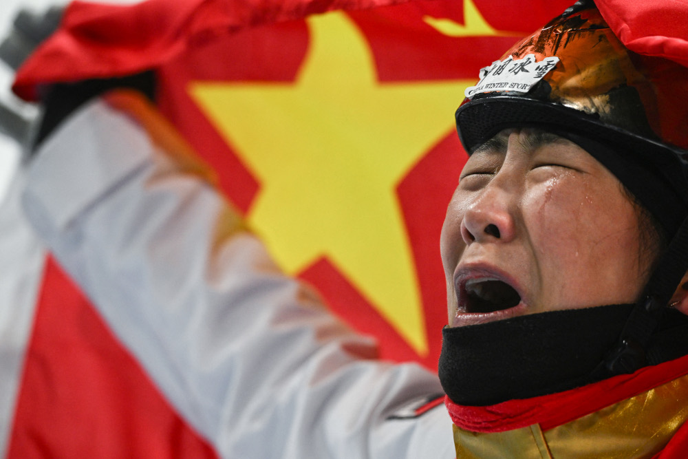 Chinau00e2u20acu2122s Xu Mengtao cries as she holds her national flag after winning the freestyle skiing womenu00e2u20acu2122s aerials final at the Genting Snow Park A & M Stadium in Zhangjiakou, February 14, 2022. u00e2u20acu201d AFP pic 