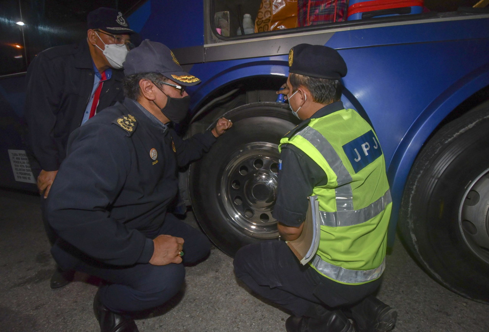 JPJ director-general Datuk Zailani Hashim (2nd left) checks the tyres of a bus during a CNY operation at the Lembah Sireh bus terminal in Kota Baru, January 31, 2022. u00e2u20acu201d Bernama pic 