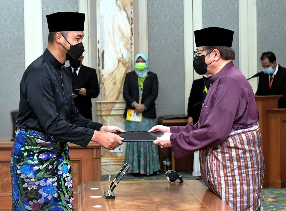 Sarawak Chief Minister Tan Sri Abang Johari Openg (right) presents the letter of appointment of political secretary to Tupong state assemblyman Fazzruddin Abdul Rahman at Wisma Bapa Malaysia building in Kuching, February 18, 2022. u00e2u20acu201d Bernama picnn