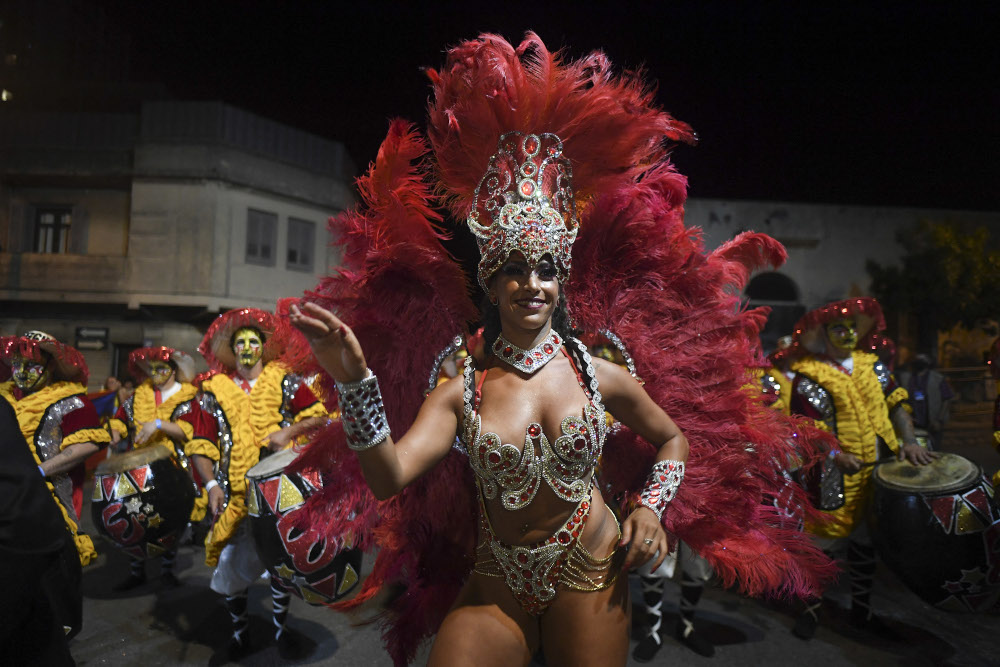 Drummers and dancers forming part of a group known as a u00e2u20acu02dccomparsau00e2u20acu2122 compete by playing and dancing to the rhythm of the traditional u00e2u20acu02dccandombeu00e2u20acu2122 music, in Montevideo on February 10, 2022. u00e2u20acu201d AFP pic