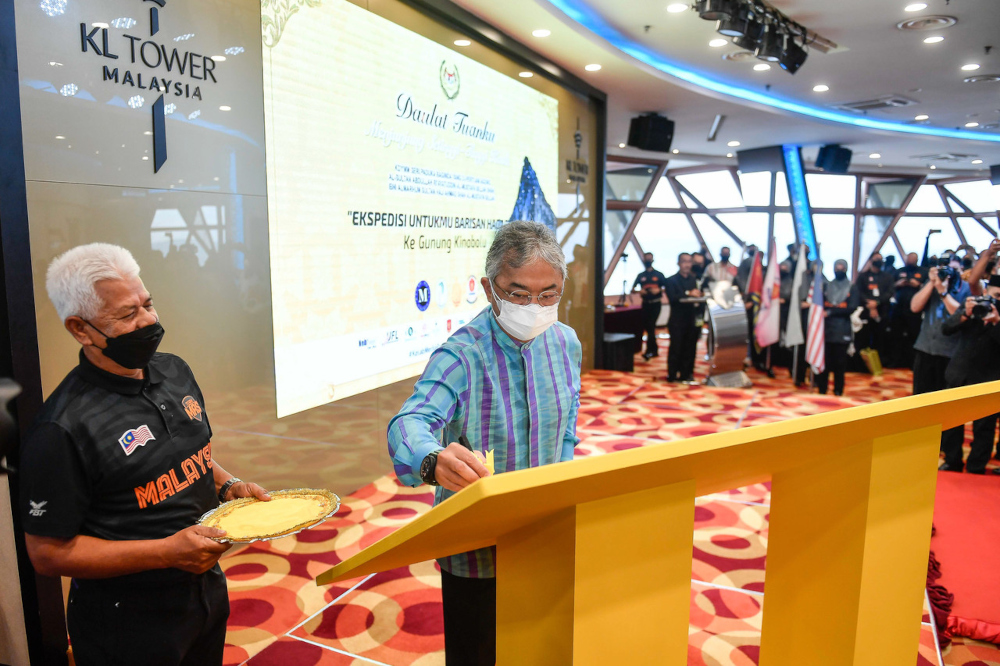The King signs a plaque in conjunction with the inauguration of the u00e2u20acu02dcEkspedisi Untukmu Barisan Hadapan Ke Gunung Kinabaluu00e2u20acu2122 programme at Menara Kuala Lumpur, February 7, 2022. u00e2u20acu2022 Bernama pic 