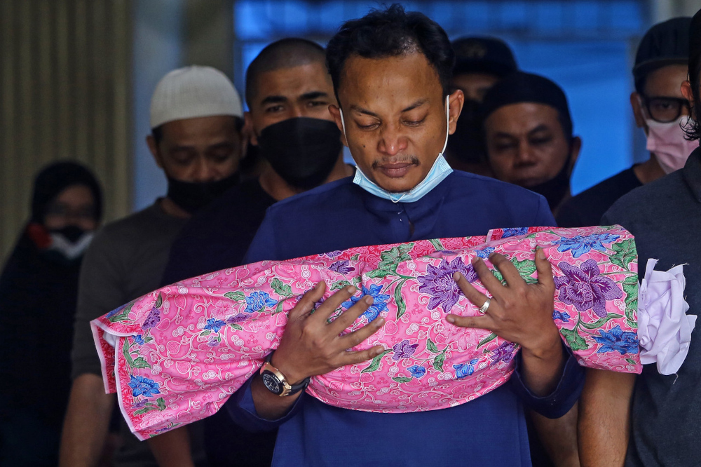 Yuseri Yusoff, father to Nour Rania Asyifaa Yuseri, holds his daughteru00e2u20acu2122s body outside the forensics room of Hospital Tuanku Jaafar in Seremban, February 23, 2022. u00e2u20acu201d Bernama pic 