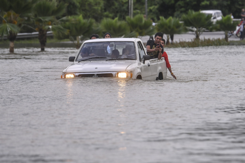 Flood victims are seen on a vehicle stuck on the flooded road after heavy rains in Hulu Terengganu February 27, 2022. u00e2u20acu201d Bernama pic