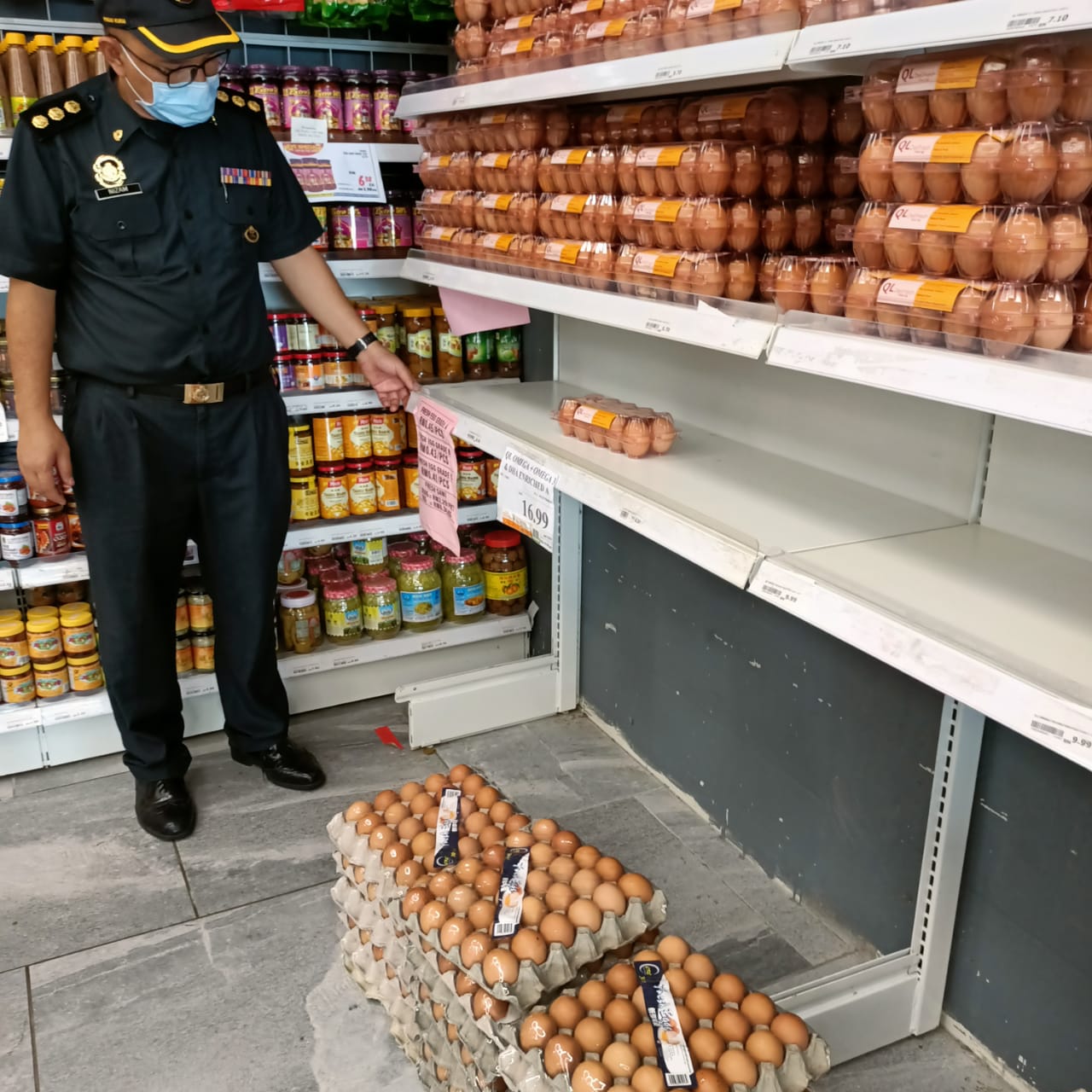 An enforcement officer inspects eggs in a local store. u00e2u20acu2022 Borneo Post pic