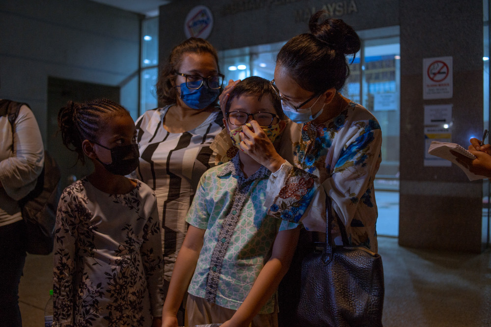 Adlyn Adam Teoh and Myra Eliza Mohd Danil with their children waiting for citizenship to be approved by the National Registration Department in Putrajaya February 21, 2022. — Picture by Shafwan Zaidon
