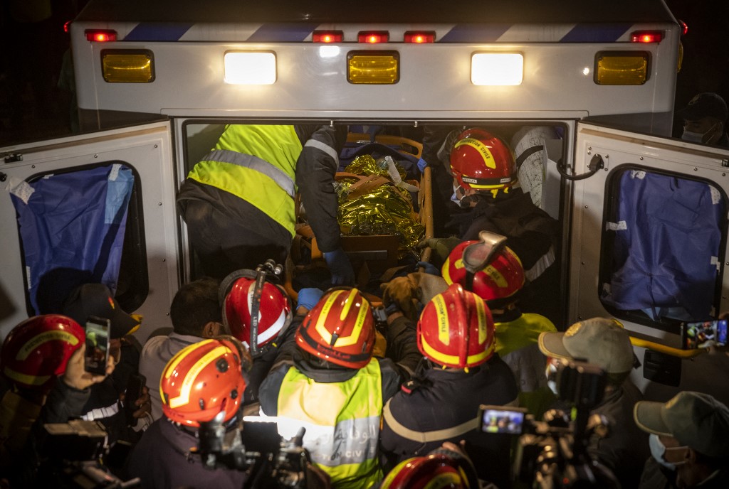 Moroccan emergency services teams carry five-year-old Rayan Oram into an ambulance after pulling him from a well shaft he fell into on February 1, in the remote village of Ighrane, February 5, 2022. u00e2u20acu201d AFP pic