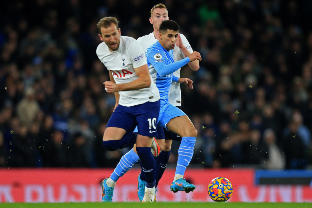 Manchester City defender Joao Cancelo (right) runs between Tottenham Hotspur midfielder Dejan Kulusevski (centre) and striker Harry Kane at the Etihad Stadium in Manchester, north-west England, February 19, 2022. u00e2u20acu201d AFP pic 