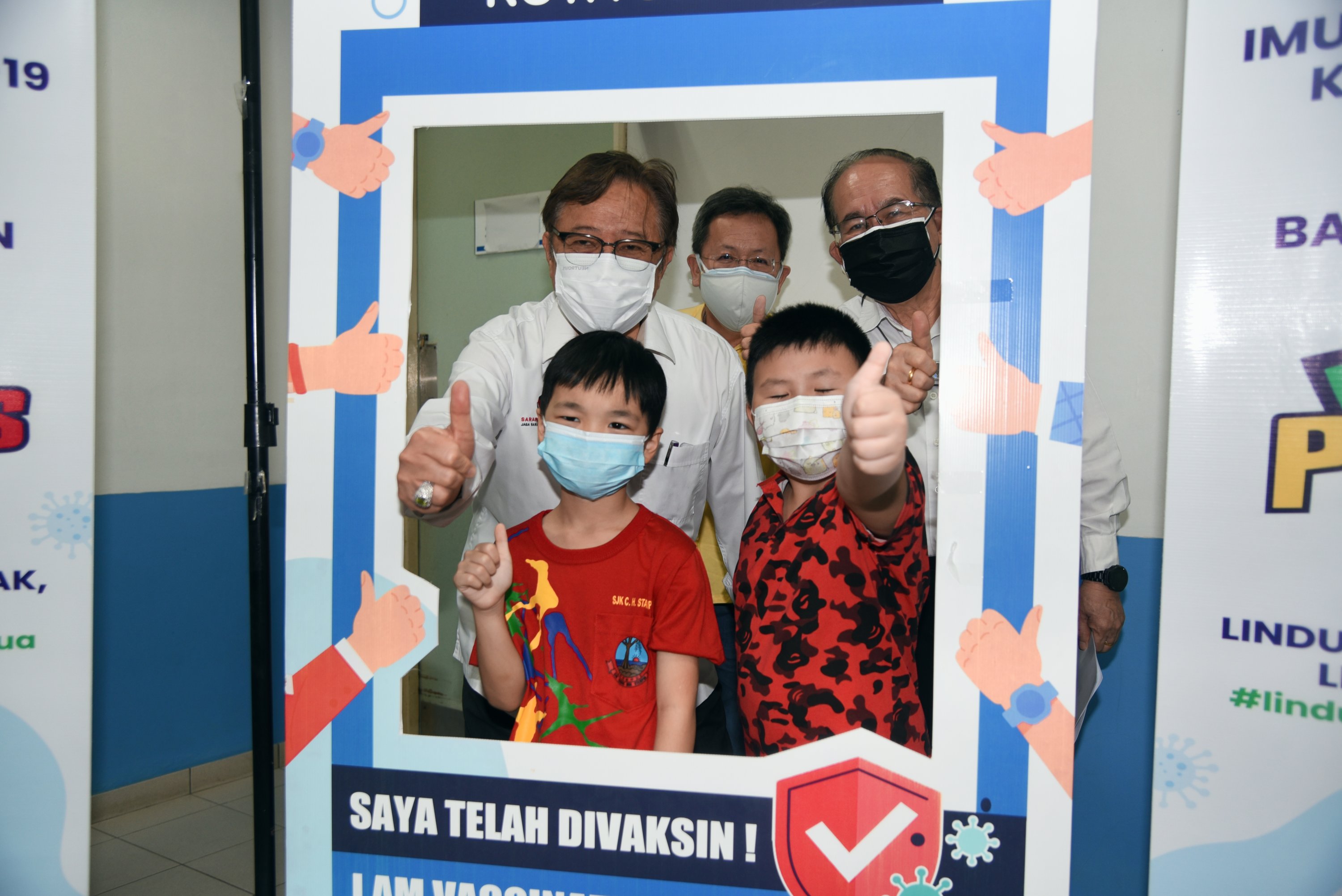 (Back row, from left) Abang Johari , Dr Sim and Uggah give the thumbs-up together with young children who were vaccinated against Covid-19 at Kota Sentosa health clinic today. u00e2u20acu201d Penerangan photo via Borneo Post