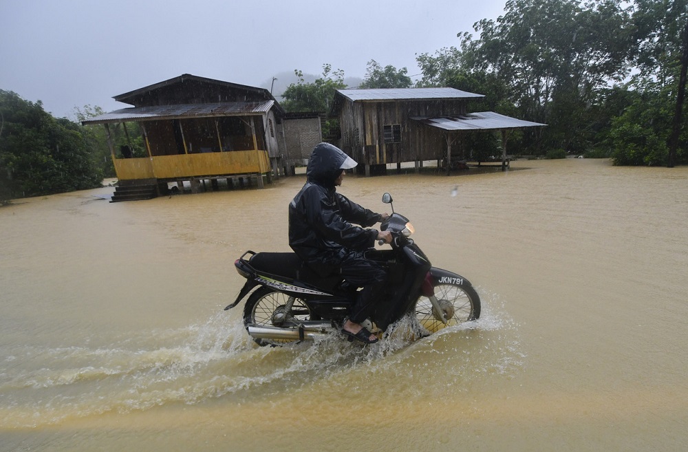 A motorcyclist rides through flood waters in Kuala Krai February 26, 2022. u00e2u20acu2022 Bernama pic