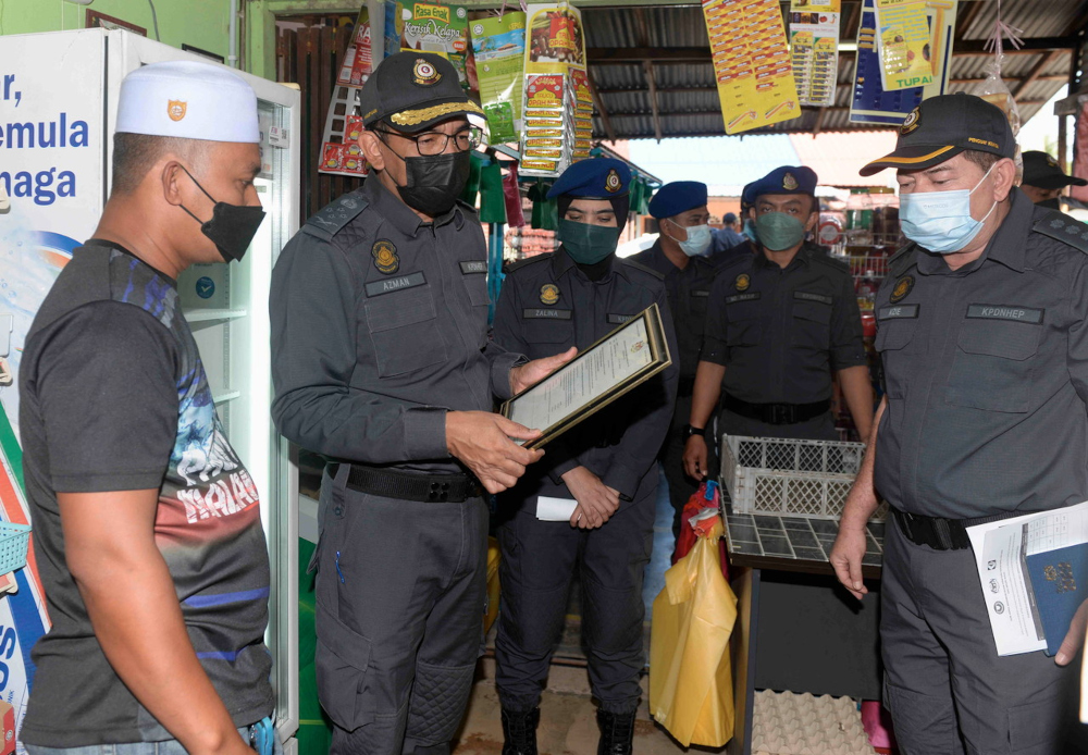 KPDNHEP enforcement director Azman Adam speaks to a trader during an inspection of the implementation of the Festive Season Maximum Price Control Scheme in Kampung Lalang, Kedah, February 2, 2022. u00e2u20acu201d Bernama pic 