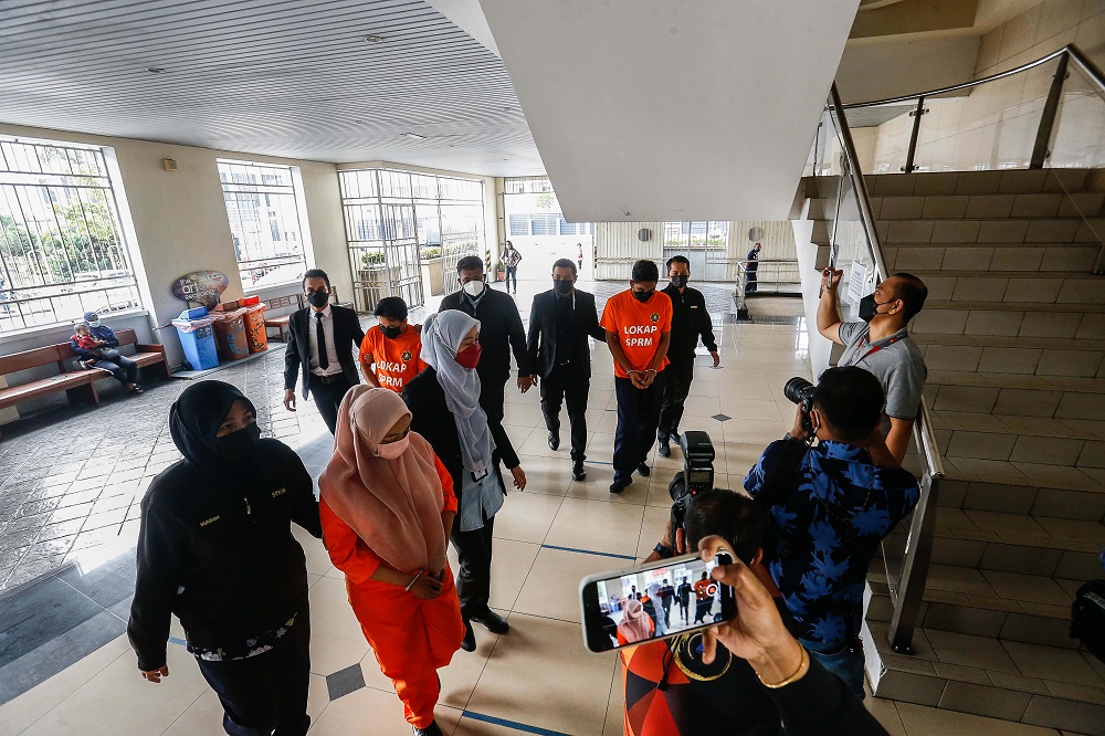 MACC officers escort three people, including a state excou00e2u20acu2122s special aide, to the Remand Court in George Town February 9, 2022. u00e2u20acu2022 Picture by Sayuti Zainudin