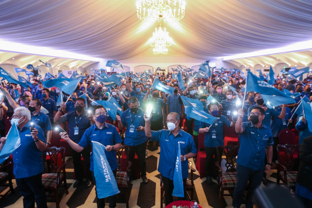 Perikatan Nasional chief Tan Sri Muhyiddin Yassin Yassin and other party leaders wave party flags during the announcement of candidates for the Johor state election at Pulai Springs Resort in Pulai, Johor, February 24, 2022. u00e2u20acu201d Picture by Hari Anggara