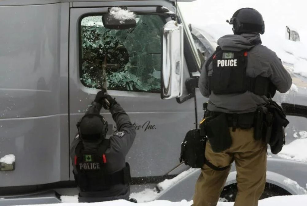 An officer smashes a truck window as police deploy to remove protesters on February 19, 2022 in Ottawa, Canada. u00e2u20acu201d AFP pic