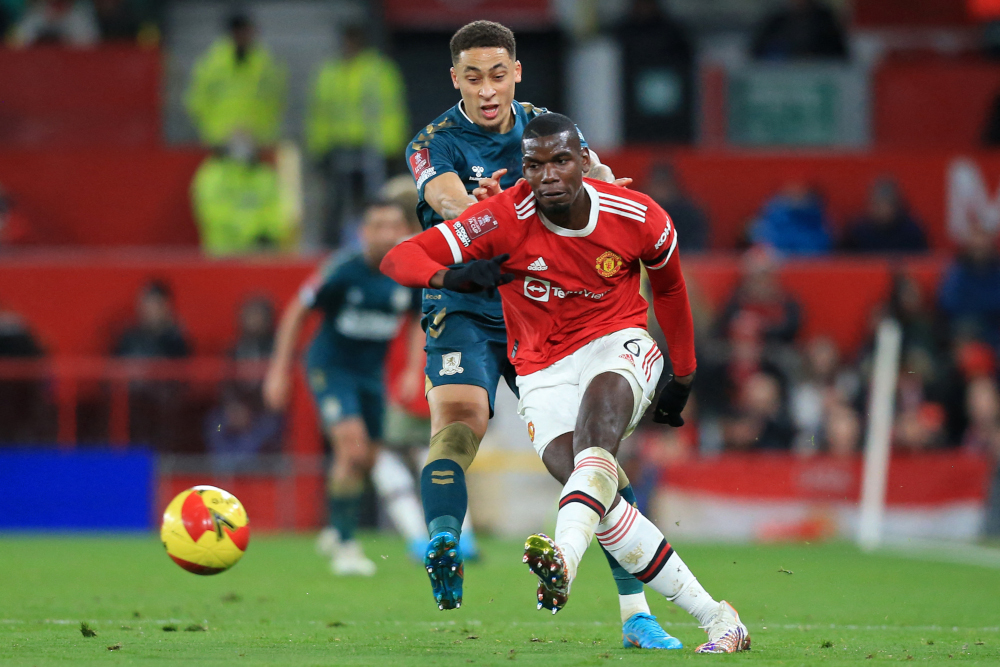 Manchester United midfielder Paul Pogba passes the ball under pressure from Middlesbrough midfielder Marcus Tavernier during the English FA Cup fourth round match at Old Trafford in Manchester, February 4, 2022. u00e2u20acu2022 AFP pic 