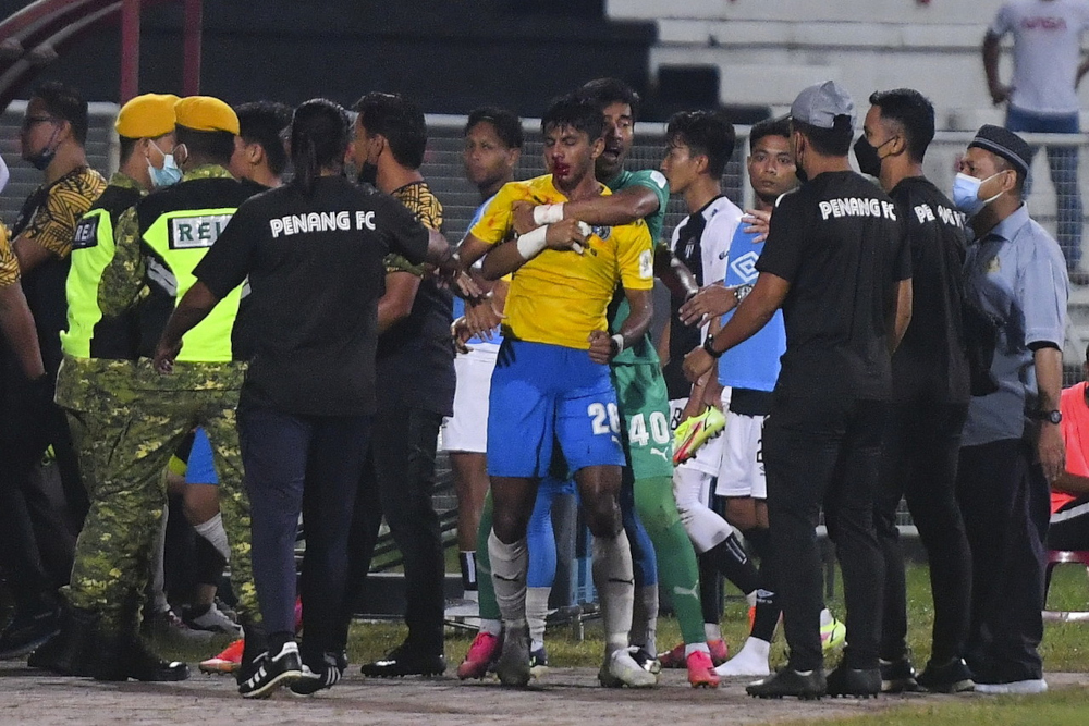 An injured Adib Raop is held by Penang FC goalkeeper Shafiq Afifi Suhaimi (6th, right) during the Terengganu Mentri Besar Cup final in Kuala Terengganu, February 9, 2022. u00e2u20acu2022 Bernama pic   