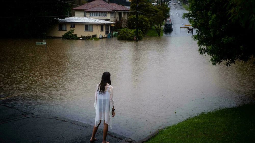 A girl looks at rising floodwaters of the Bremer river in West Ipswich, Queensland. u00e2u20acu201d AFP pic