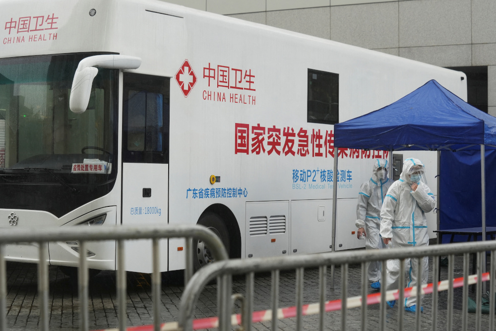 Medical workers wearing protective suits walk past a makeshift testing site next to a mobile testing vehicle dispatched from mainland China, following the Covid-19 outbreak, in Tung Chung, Hong Kong February 21, 2022. u00e2u20acu201d Reuters pic