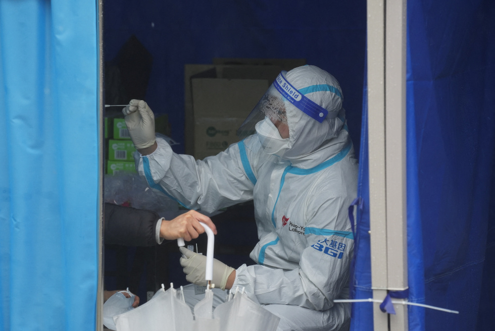 A medical worker collects a swab sample from a person at a makeshift testing site next to a mobile testing vehicle dispatched from mainland China in Tung Chung, Hong Kong February 21, 2022. u00e2u20acu201d Reuters pic