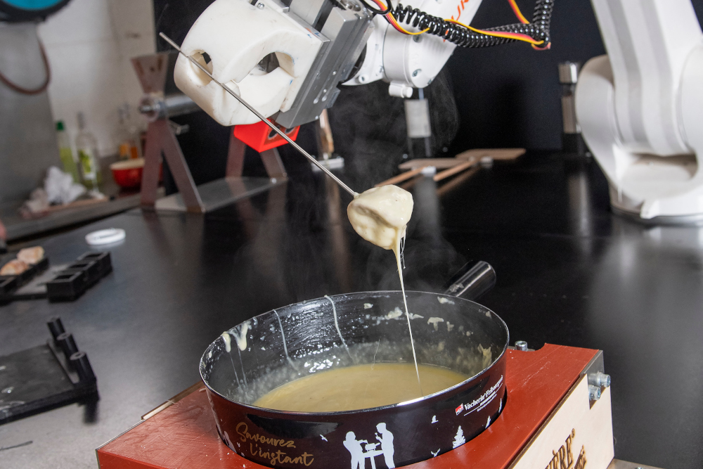 This picture shows a robot built by the start-up Workshop 4.0 cooking a Swiss fondue in Sierre, February 18, 2022. u00e2u20acu201d AFP picnn