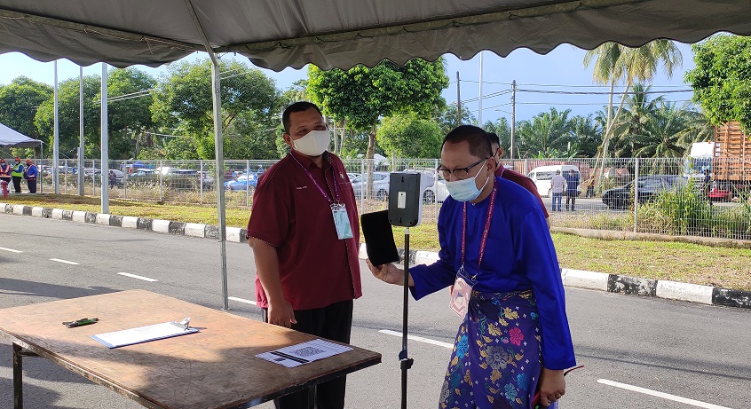 Umno supreme council member Datuk Mohd Puad Zakarshi gets his temperature checked before entering the nomination centre in Batu Pahat February 26, 2022. u00e2u20acu2022 Picture by Kenneth Tee