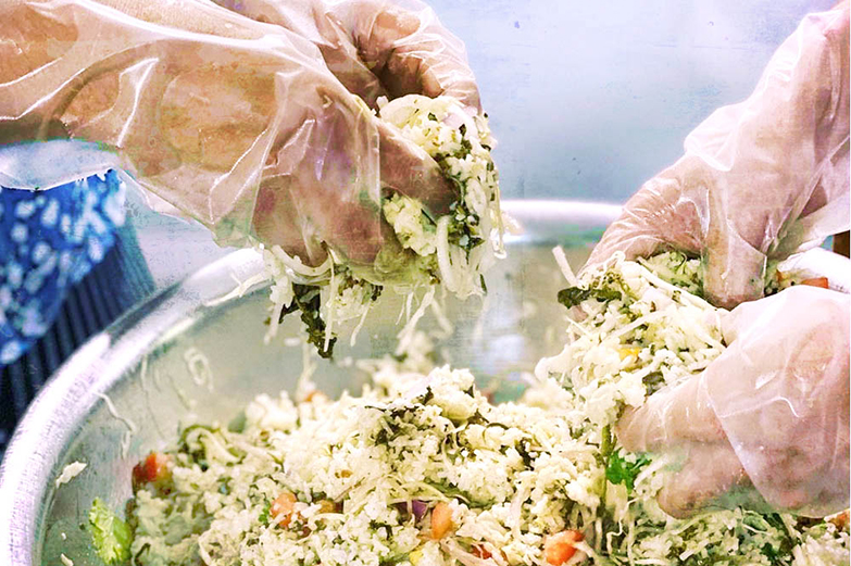Mixing 'lahpet thoke' with rice for a breakfast order.