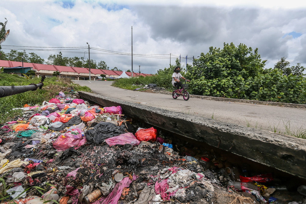 Heaps of decomposing rubbish emit an unmistakable stench of decomposition by the side of the road leading into the main settlement from the main commerce area in Kampung Bumiputera Dalam. — Picture by Hari Anggara
