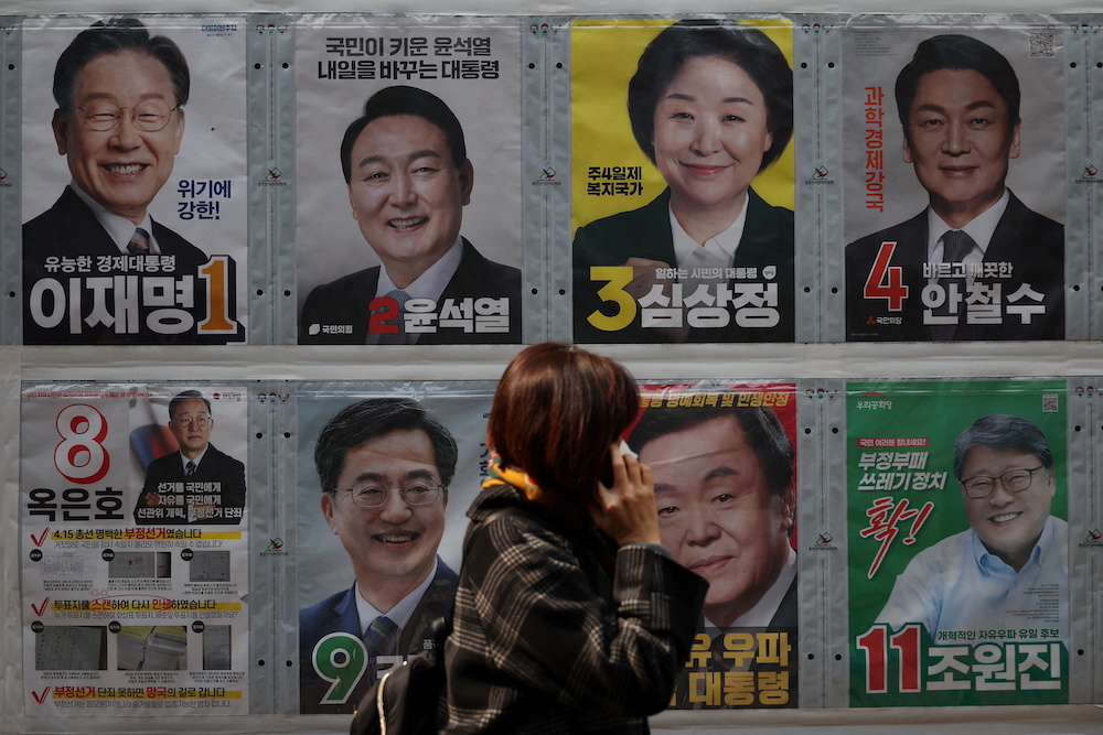 A woman walks past posters of candidates for the upcoming March 9 presidential election in Seoul, South Korea March 7, 2022. u00e2u20acu201d Reuters pic