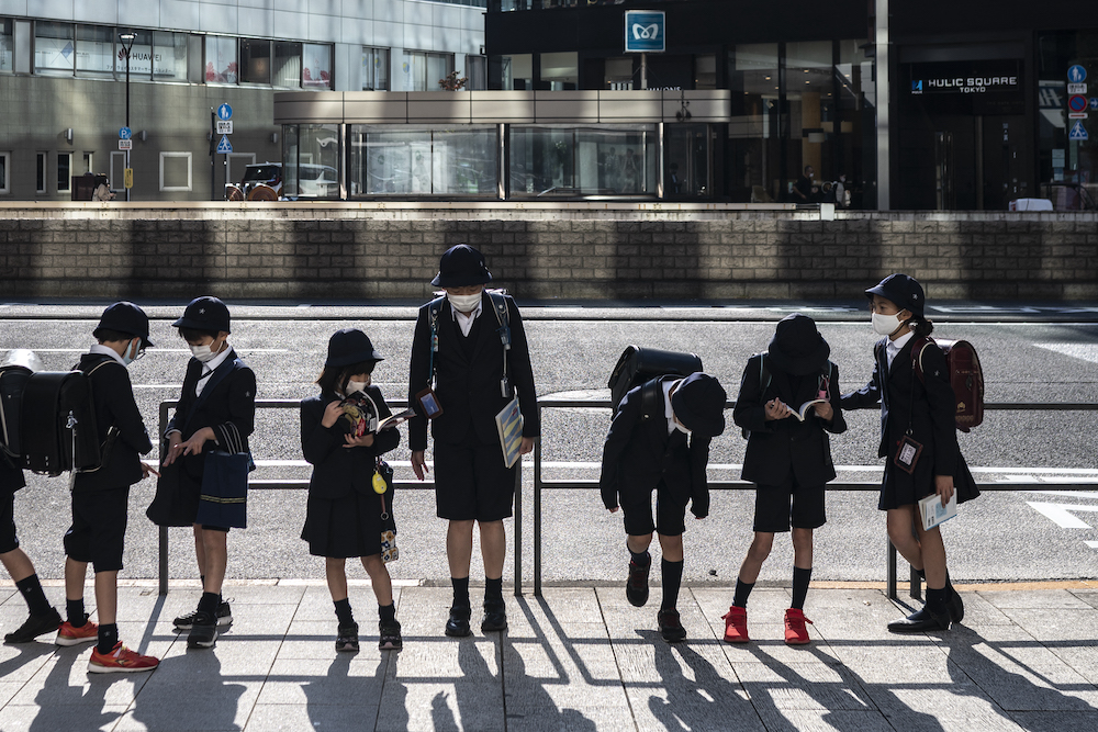 In this file photo taken on November 17, 2021 pupils wait for the bus after school in Tokyo's Ginza area. u00e2u20acu201d AFP pic