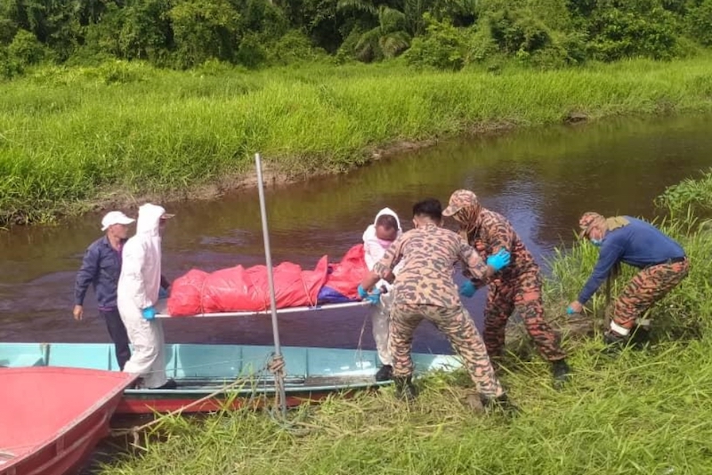 Fire and Rescue Department personnel arrive at the riverbank with Demitu00e2u20acu2122s body. u00e2u20acu201d Borneo Post pic