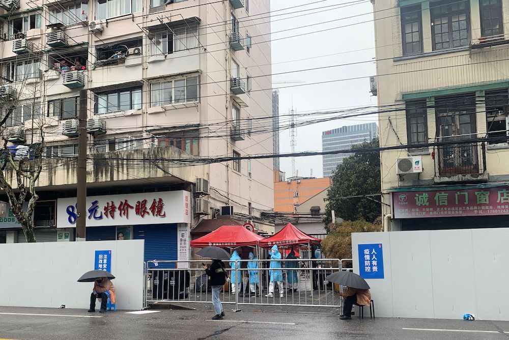 People walk past fences surrounding a residential compound, following the Covid-19 outbreak in Shanghai, China March 17, 2022. u00e2u20acu201d Reuters pic