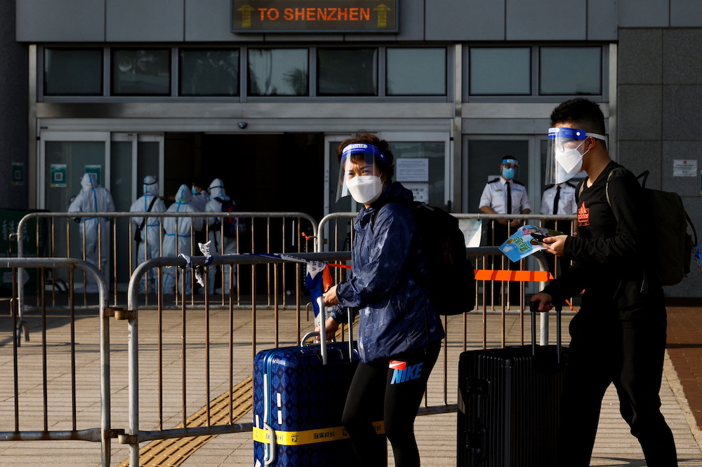 Travellers wearing face mask and shield, walk at the China-Hong Kong border of Shenzhen Bay Port, during the Covid-19 pandemic in Hong Kong, China March 14, 2022. u00e2u20acu201d Reuters pic