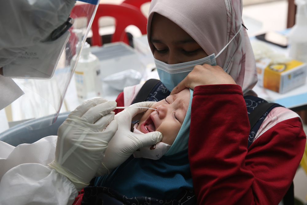 Scenes like this one of a child undergoing a Covid-19 swab test have become commonplace during the pandemic. u00e2u20acu201d Picture by Choo Choy May