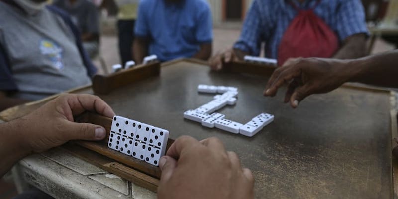 Elderly people play dominoes on tables set up at the Plaza Bolivar of the Petare neighbourhood in Caracas. u00e2u20acu201d AFP pic