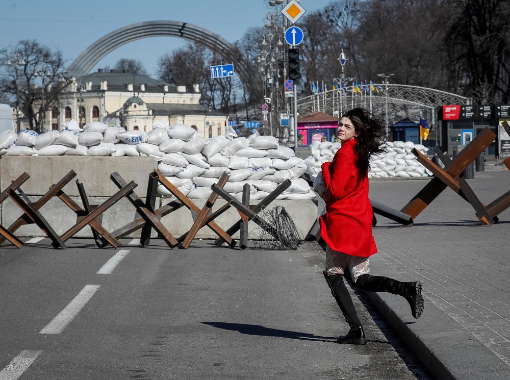 A woman runs across the street next to an anti-tank constructions in central Kyiv, Ukraine March 10, 2022. u00e2u20acu201d Reuters pic