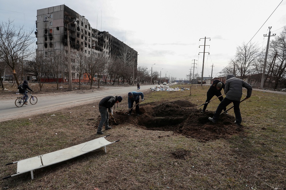 People dig a grave for victims killed during Ukraine-Russia conflict in a street in the besieged southern port city of Mariupol, Ukraine March 20, 2022. u00e2u20acu201d Reuters pic
