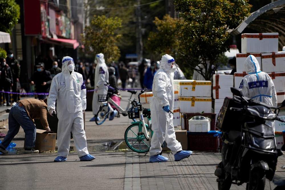 Police and security members in protective suits stand outside cordoned off food stores following the coronavirus disease outbreak in Shanghai March 29, 2022. u00e2u20acu201d Reuters pic 