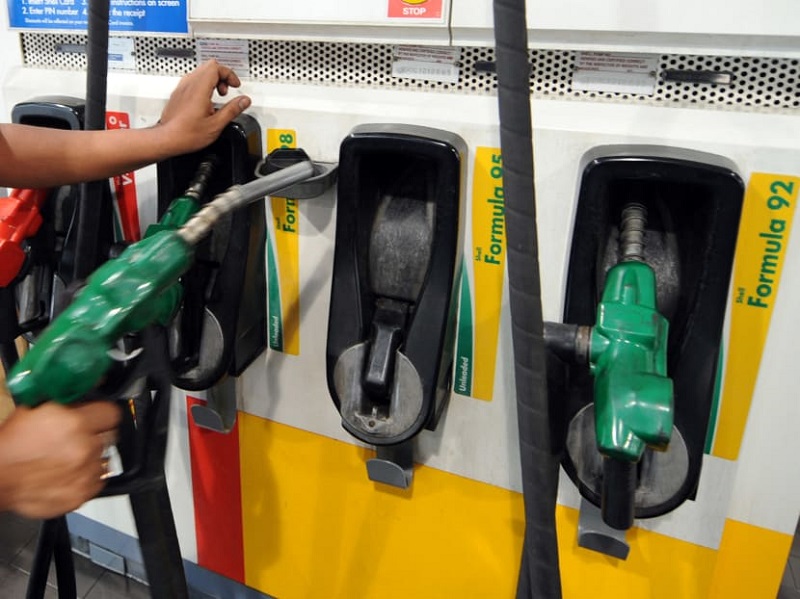 A pump attendant at a petrol kiosk in Singapore. u00e2u20acu201d AFP pic