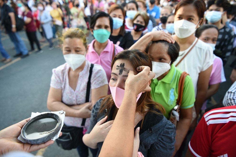 A Catholic nun applies ash to a womanu00e2u20acu2122s forehead on the observance of Ash Wednesday at a church ground in Manila March 2, 2022. u00e2u20acu201d AFP pic