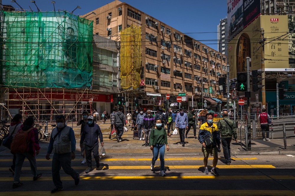 People wearing face masks cross a street in Hong Kong March 8, 2022, amid the cityu00e2u20acu2122s worst-ever Covid-19 coronavirus outbreak. u00e2u20acu201d AFP pic