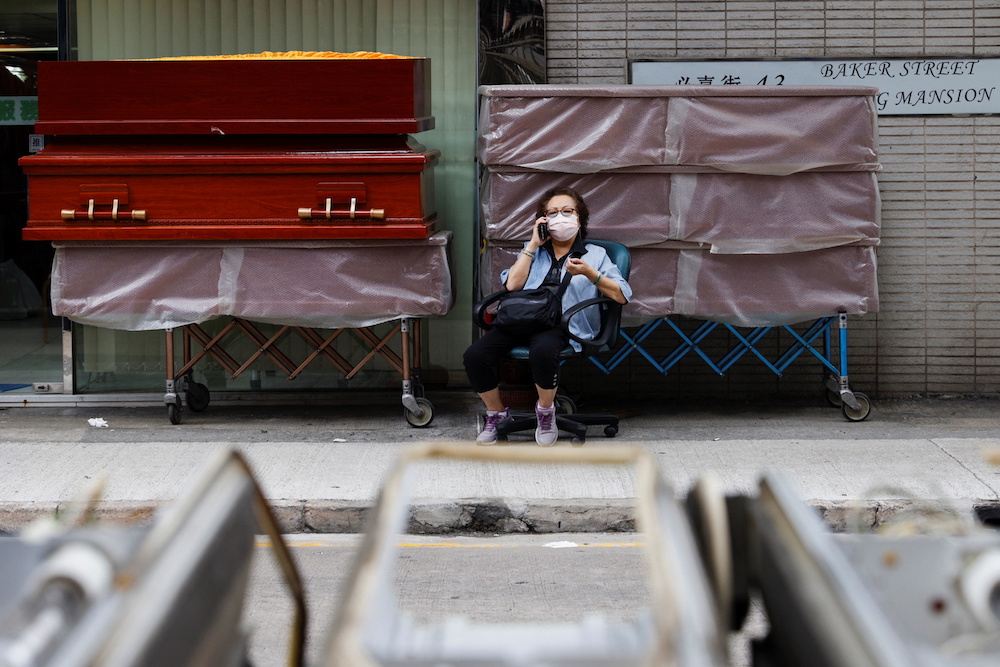 A woman sits in front of coffins outside a store as mortuaries run short of coffins amid Shenzhen lockdown during the coronavirus disease (Covid-19) pandemic in Hong Kong, China, March 16, 2022. u00e2u20acu201d Reuters picnn