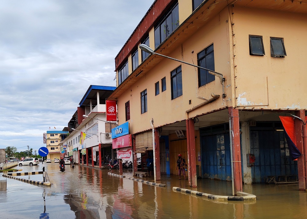 Motorcyclists ride through flood waters at China Street. u00e2u20acu201d Borneo Post Online pic